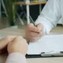 Doctor writing notes on a clipboard